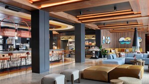 Een moderne lobby met een bar, zitplaatsen en een grote bank.