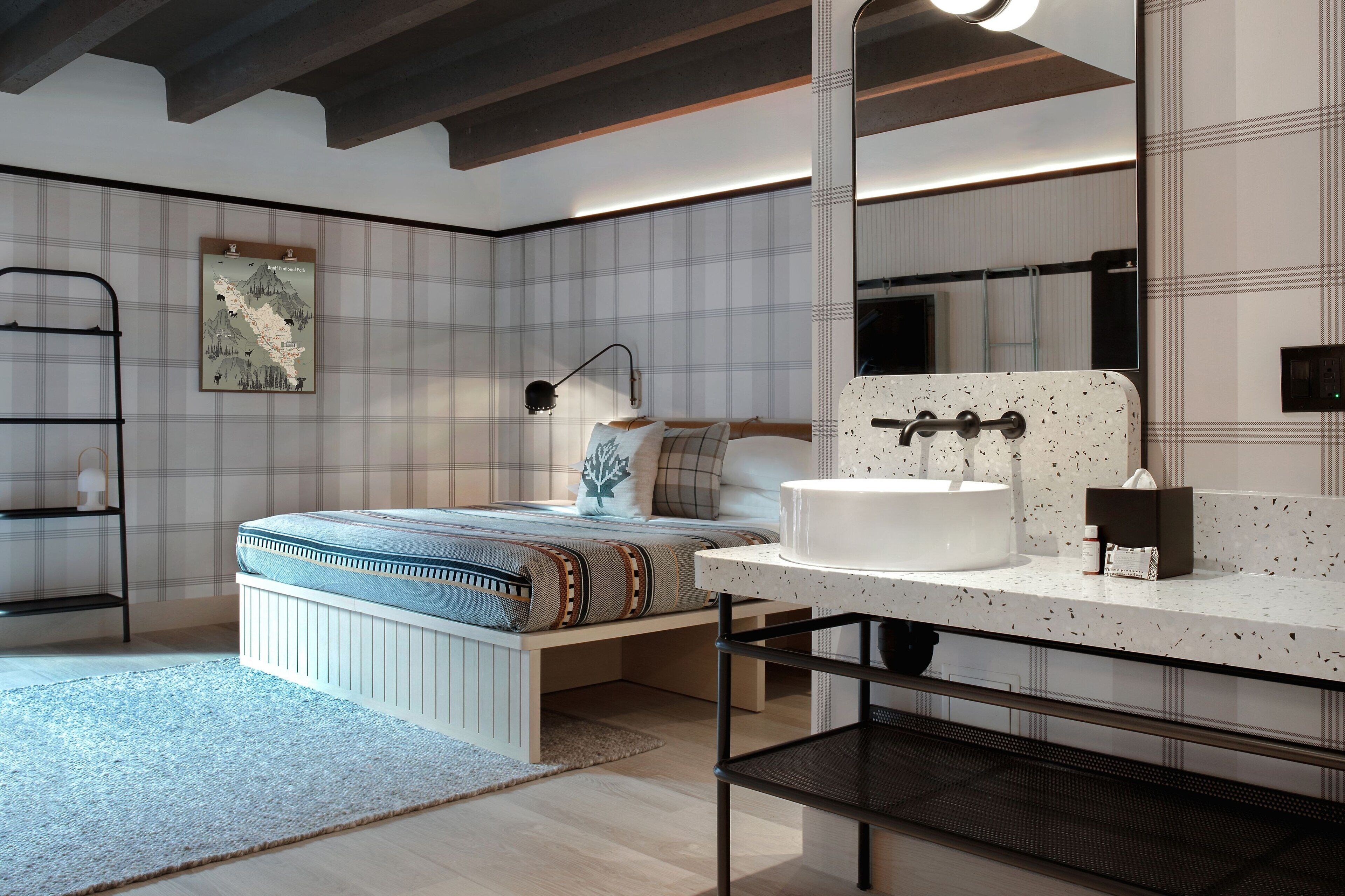Un dormitorio con cama, mesita de noche, lámpara y un espejo grande.