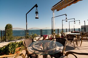 An outdoor seating area with wicker furniture, a glass table, and potted plants. - Artefes Hotel Old City & Spa (Istanbul)