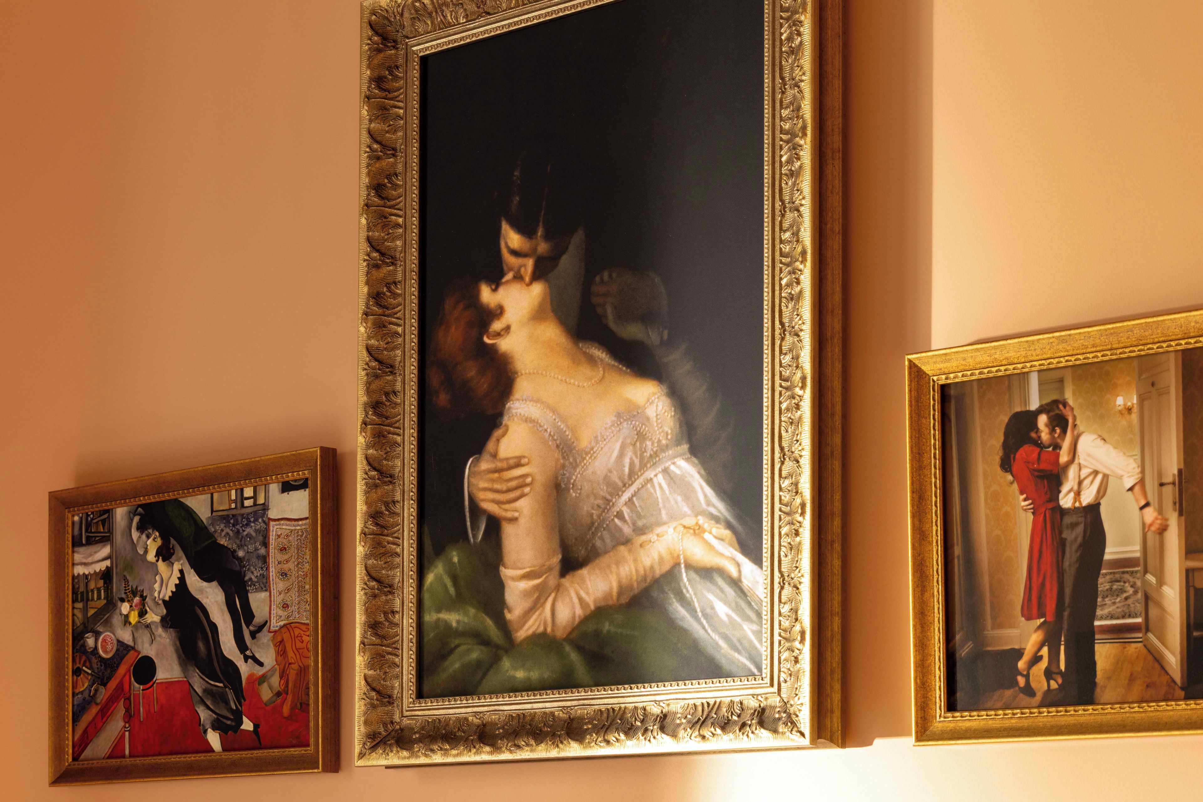 Drei gerahmte Gemälde an einer Wand.