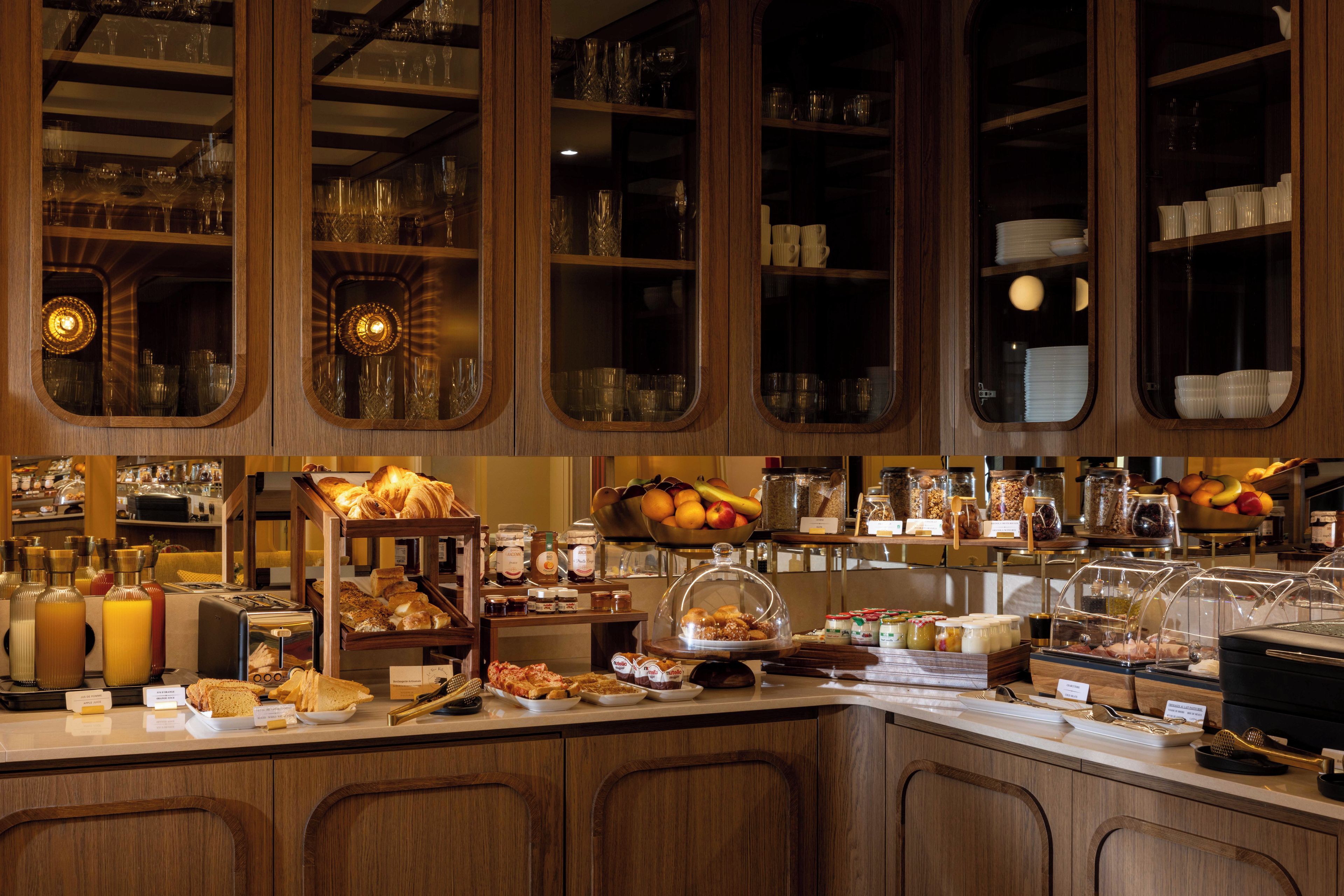 Un espace buffet proposant une variété de plats et de boissons, ainsi que de la vaisselle en verre.