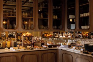Un espace buffet proposant une variété de plats et de boissons, ainsi que de la vaisselle en verre.