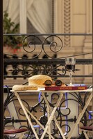 En balkon med gelænder, en fletkurv hat, et vinglas og en bog med titlen 'RENÉ'.
