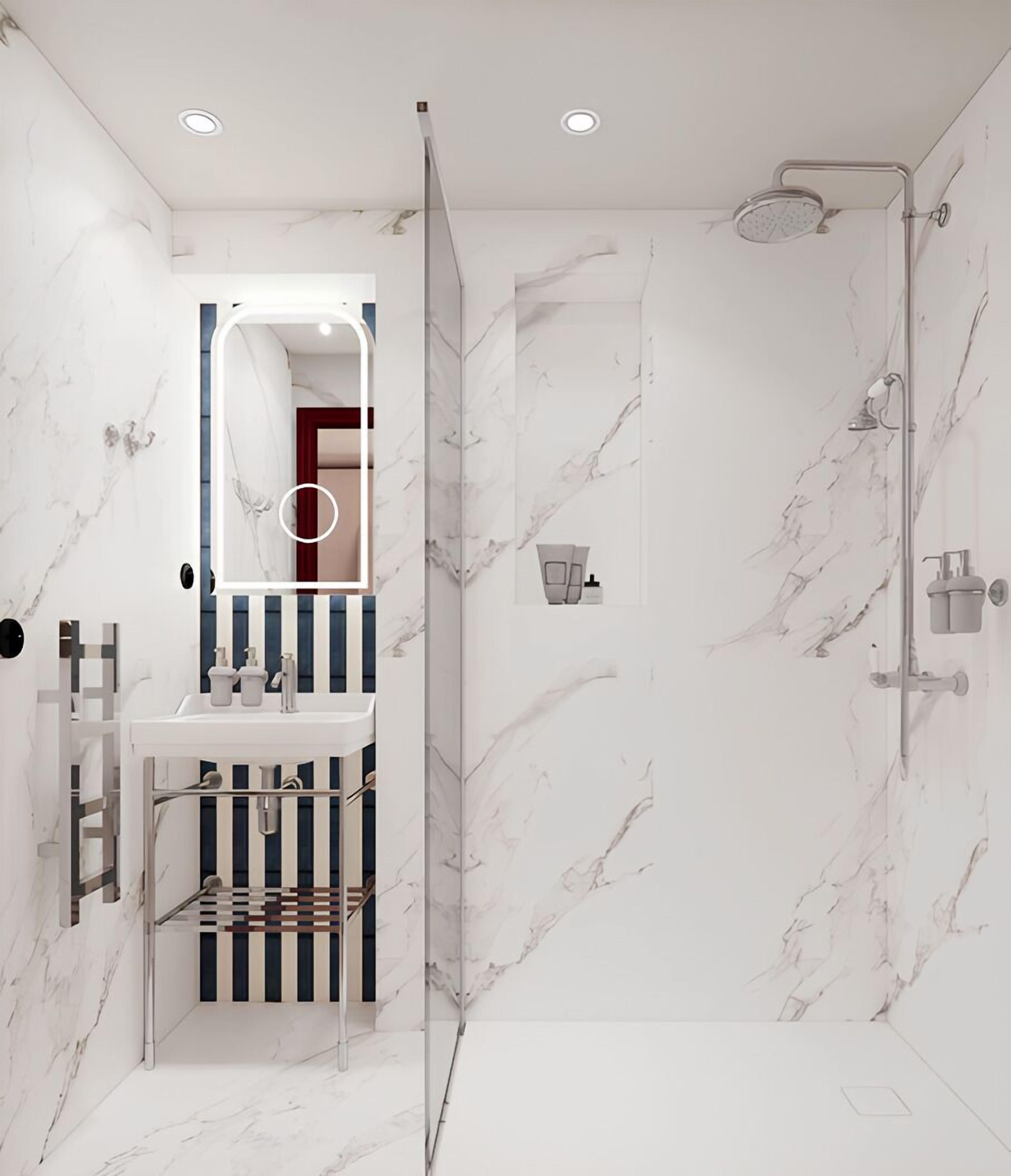 Une salle de bain moderne avec une douche, un lavabo doté d’un porte-serviettes à rayures et un miroir avec un cadre rouge.