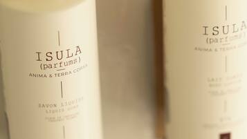 Dos botellas de jabón Isula (perfumes) con dispensador de bomba dorada y negra.