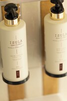 Two bottles of Isula (parfums) soap with a gold and black pump dispenser.