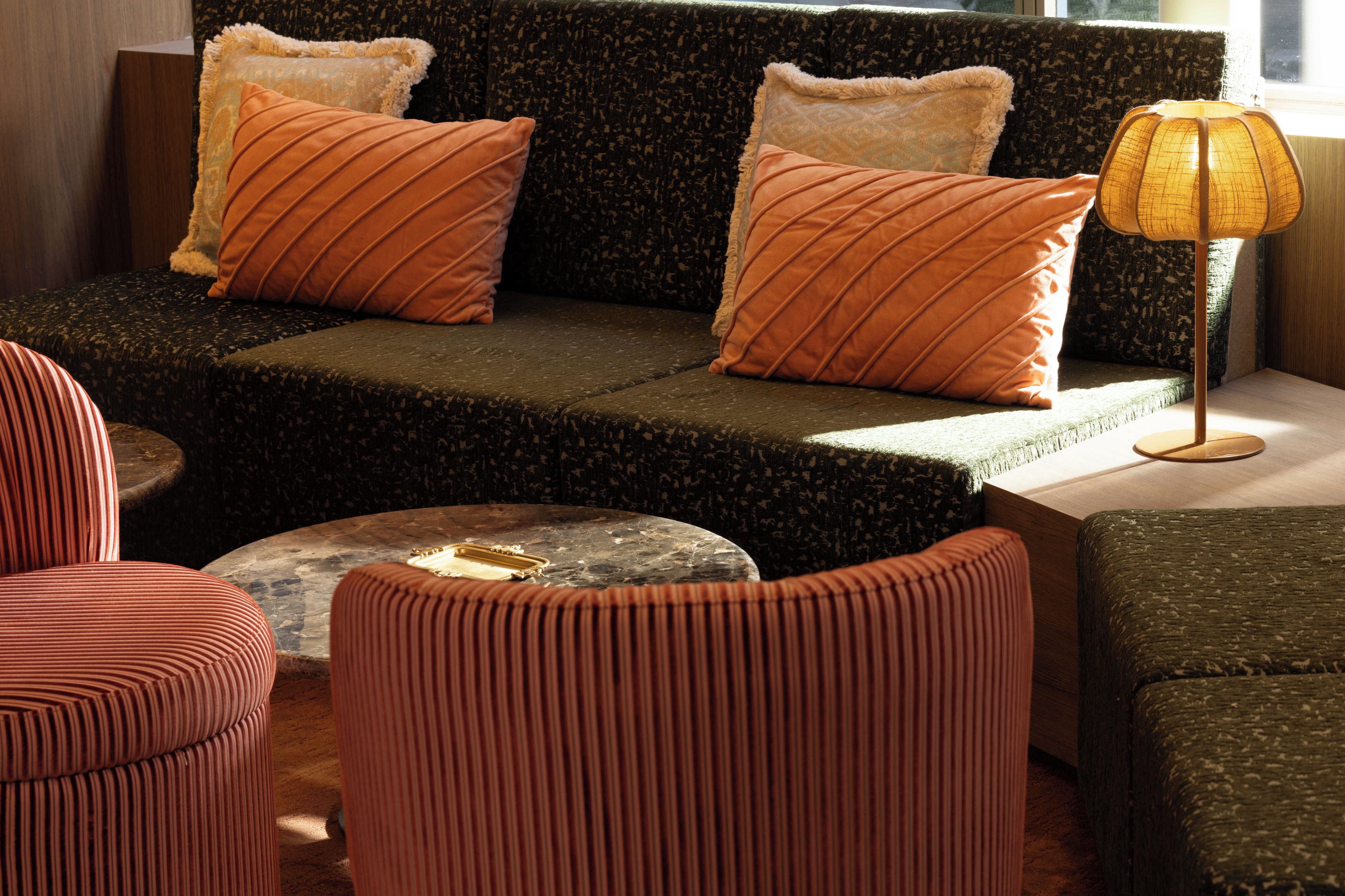 A modern living room with a sofa, two armchairs, a coffee table, and a floor lamp.