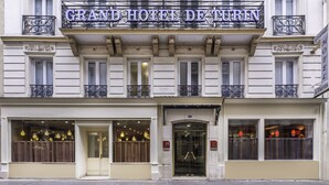 The facade of the Grand Hotel de Turin with a classic architectural style, featuring ornate iron balconies and a prominent entrance with glass doors. - Grand Hotel De Turin (Paris)