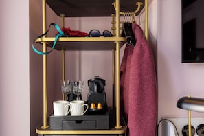 A room with a gold-framed shelf unit containing a kettle, two cups, and a small black box. - Grand Hotel De Turin (Paris)