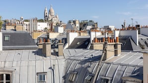 Un paisaje urbano con múltiples tejados, algunos con chimeneas y otros planos.