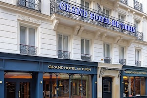 The exterior of the Grand Hotel de Turin with its classic architecture and signage.