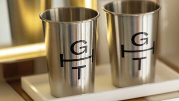 Two stainless steel tumblers with the letters 'GFT' on a white tray.