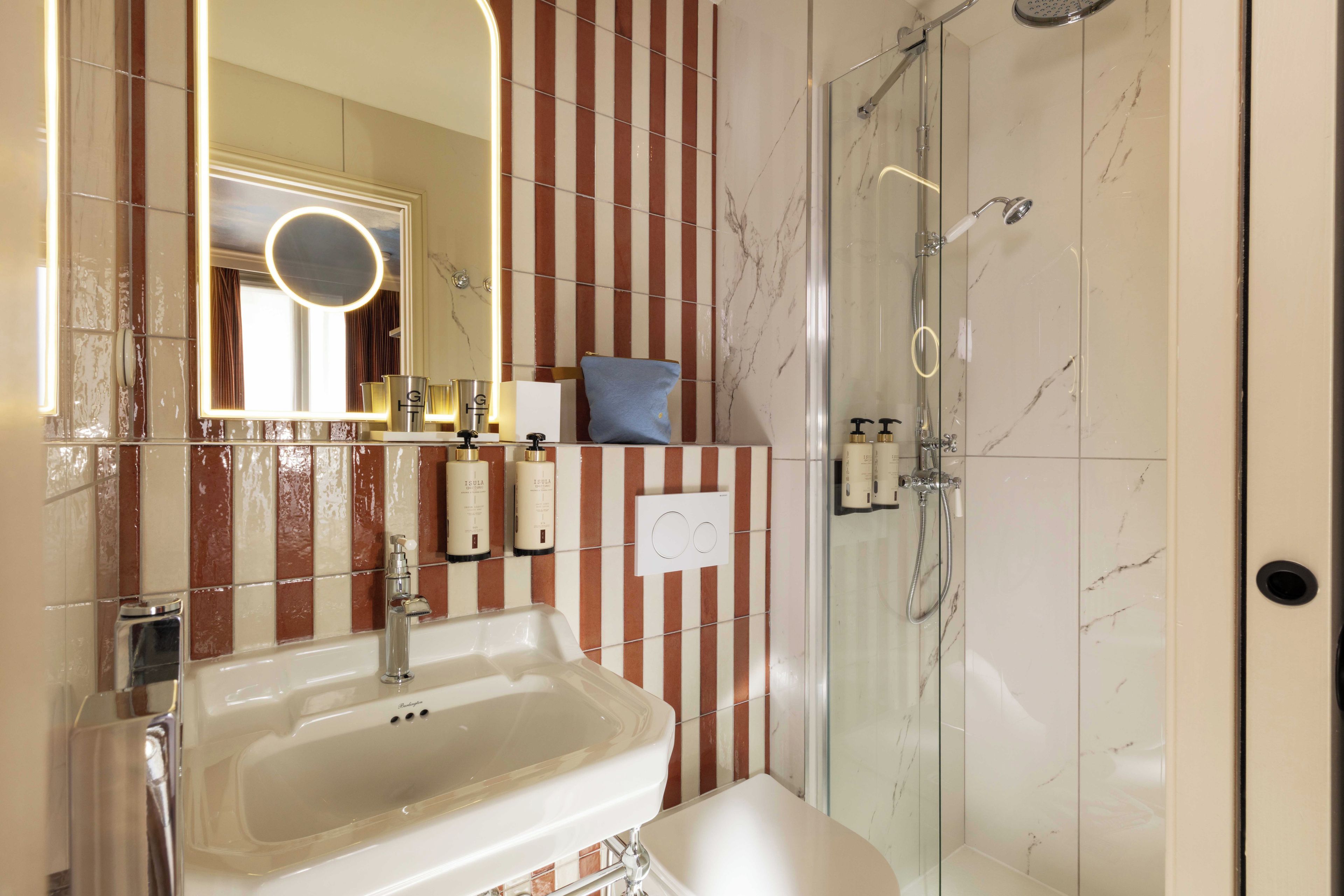 Een badkamer met een wastafel, spiegel en douche.
