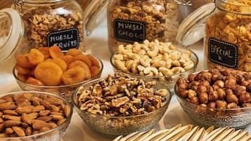 Assortimento di noci e frutta secca in vasetti e ciotole di vetro.