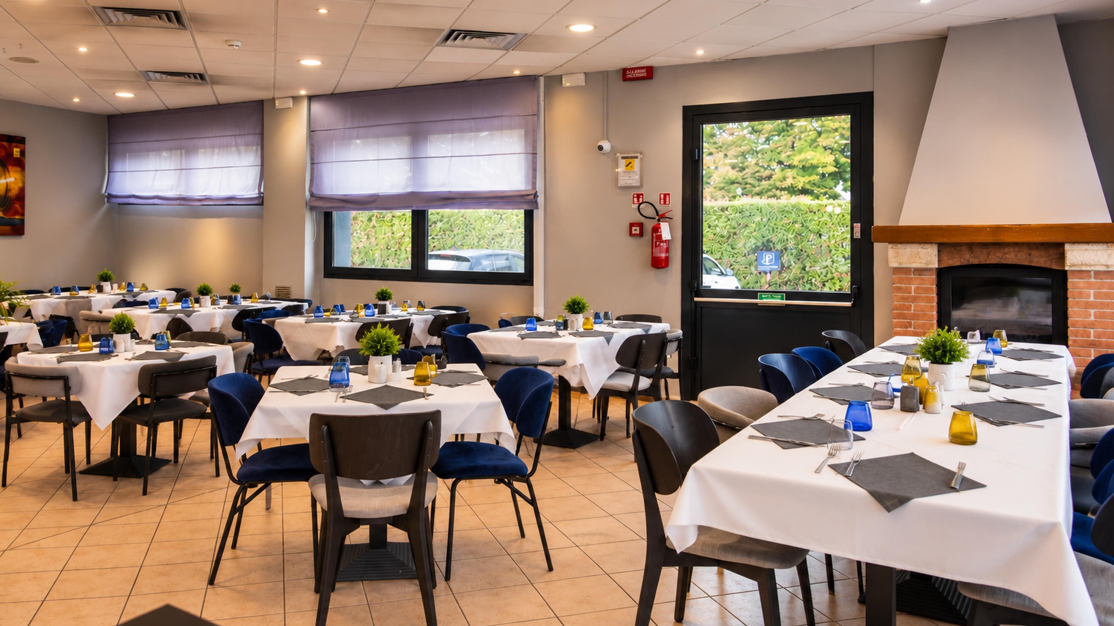 A dining area with multiple tables set for guests, equipped with chairs and table settings.