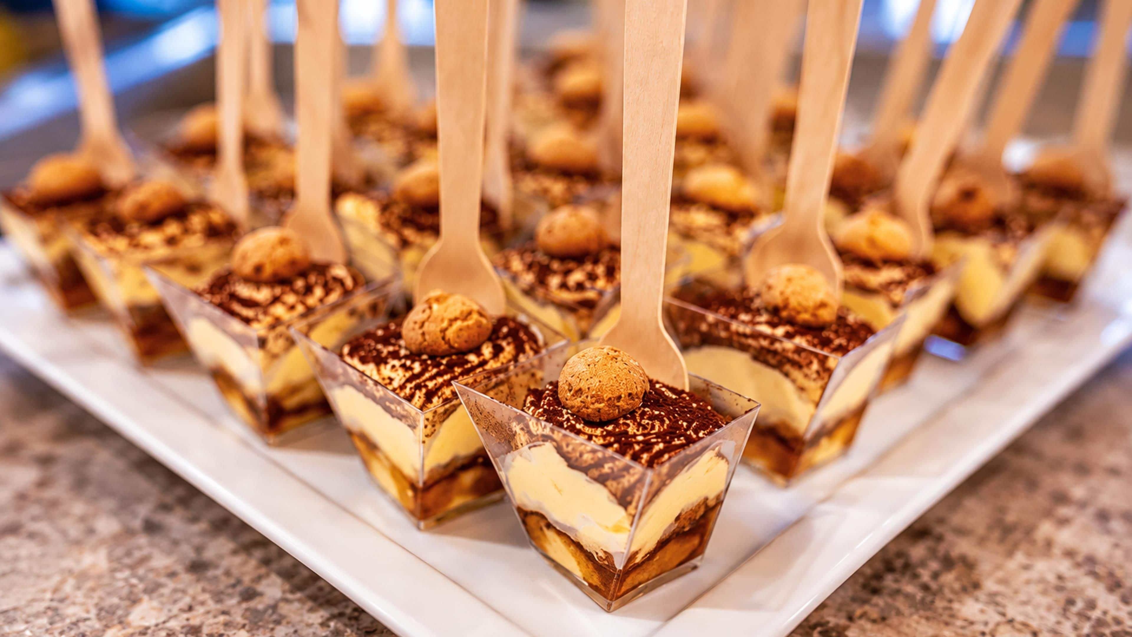 A tray of dessert cubes with a scoop of ice cream on top, arranged on a white plate.