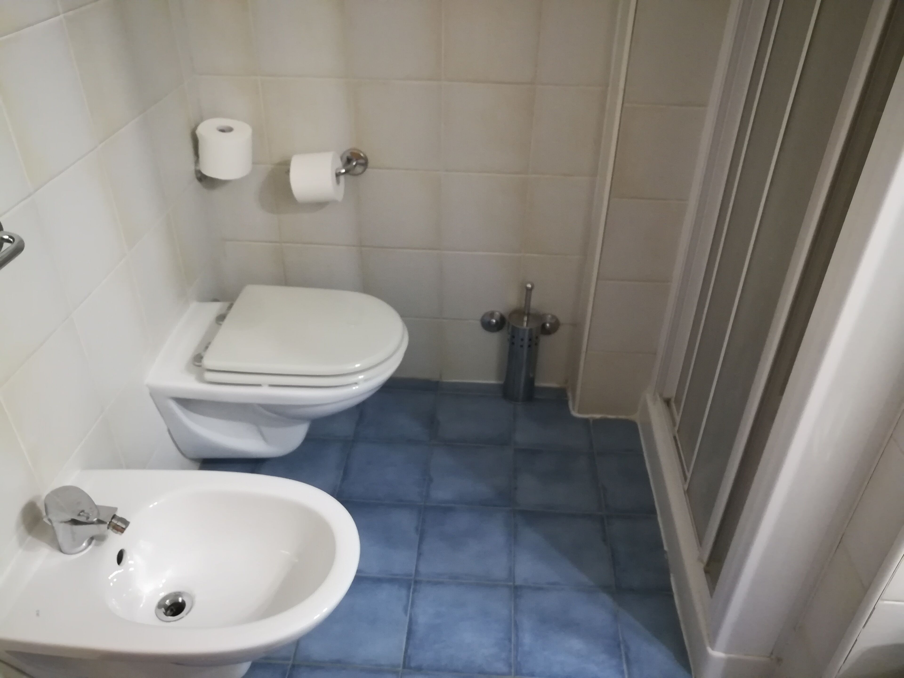 A bathroom with a toilet, bidet, and sink.