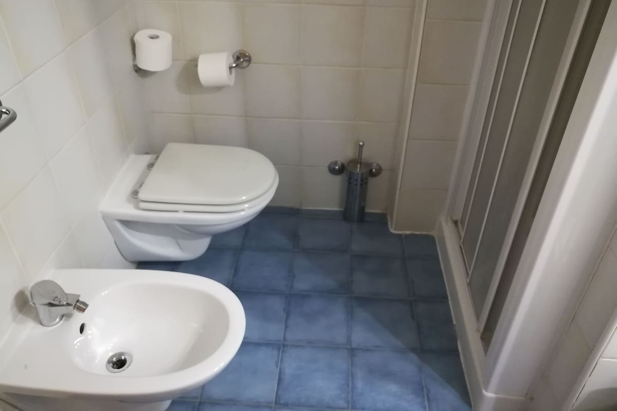Un baño con inodoro, bidé y lavamanos.