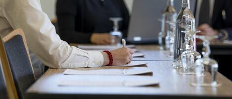 Una mesa de conferencias con documentos, una computadora portátil y botellas de agua.
