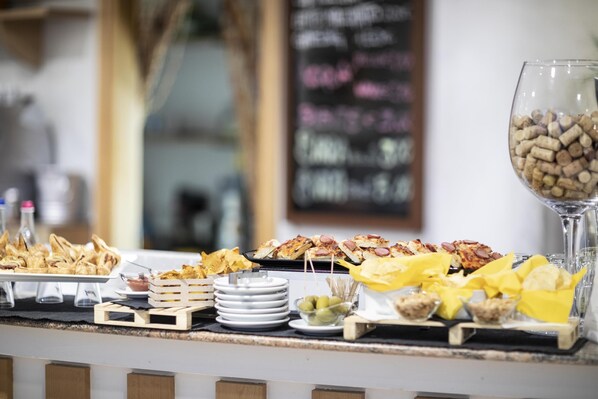 Una mesa de buffet con diferentes platos y una copa de vino.
