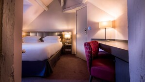 A hotel room with a bed, bedside table, lamp, and a chair. - Masséna Hôtel (Paris)