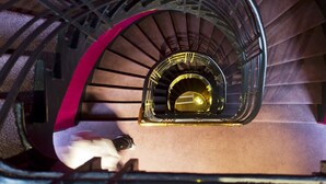 A spiral staircase with a metallic railing and a central illuminated area. - Masséna Hôtel (Paris)