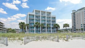 Un hôtel à plusieurs étages, doté de balcons et offrant une vue sur la plage.
