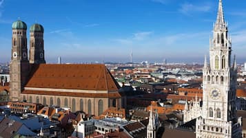 Um edifício histórico com duas torres imponentes e um grande campanário, cercado por uma área urbana densa com arquitetura variada.