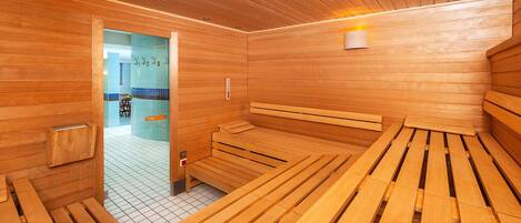 Una sauna con bancos de madera y suelo de baldosas.