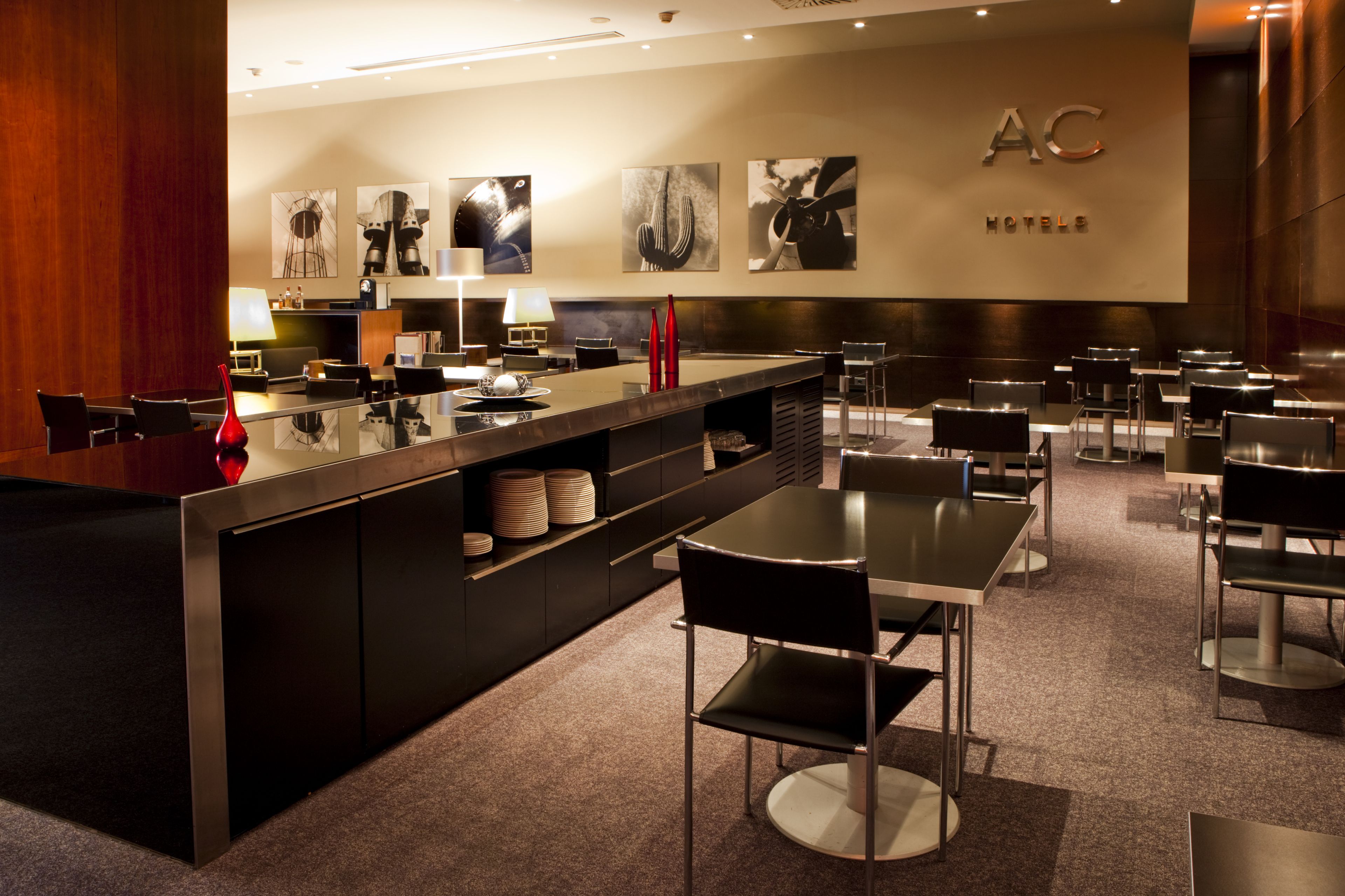 A modern hotel lobby with a reception desk, seating area, and artwork on the walls.