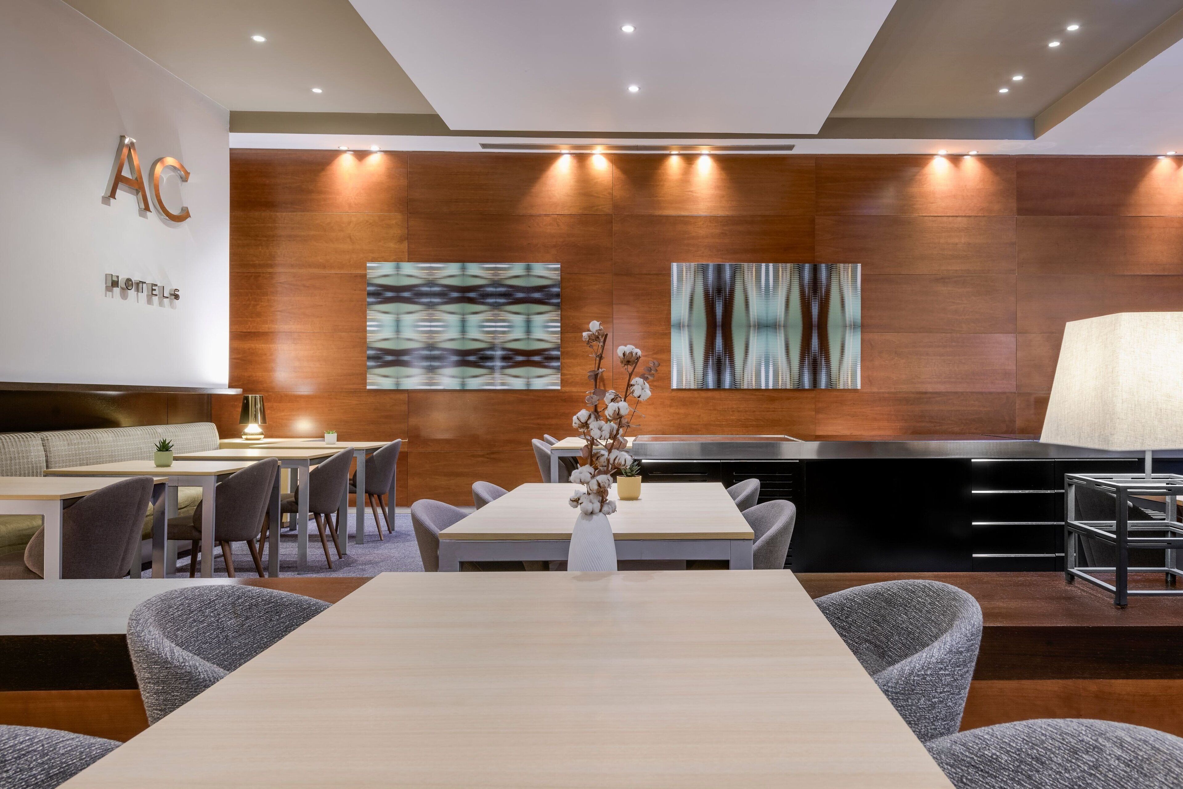 A hotel lobby with a reception desk, seating area, and artwork on the walls.
