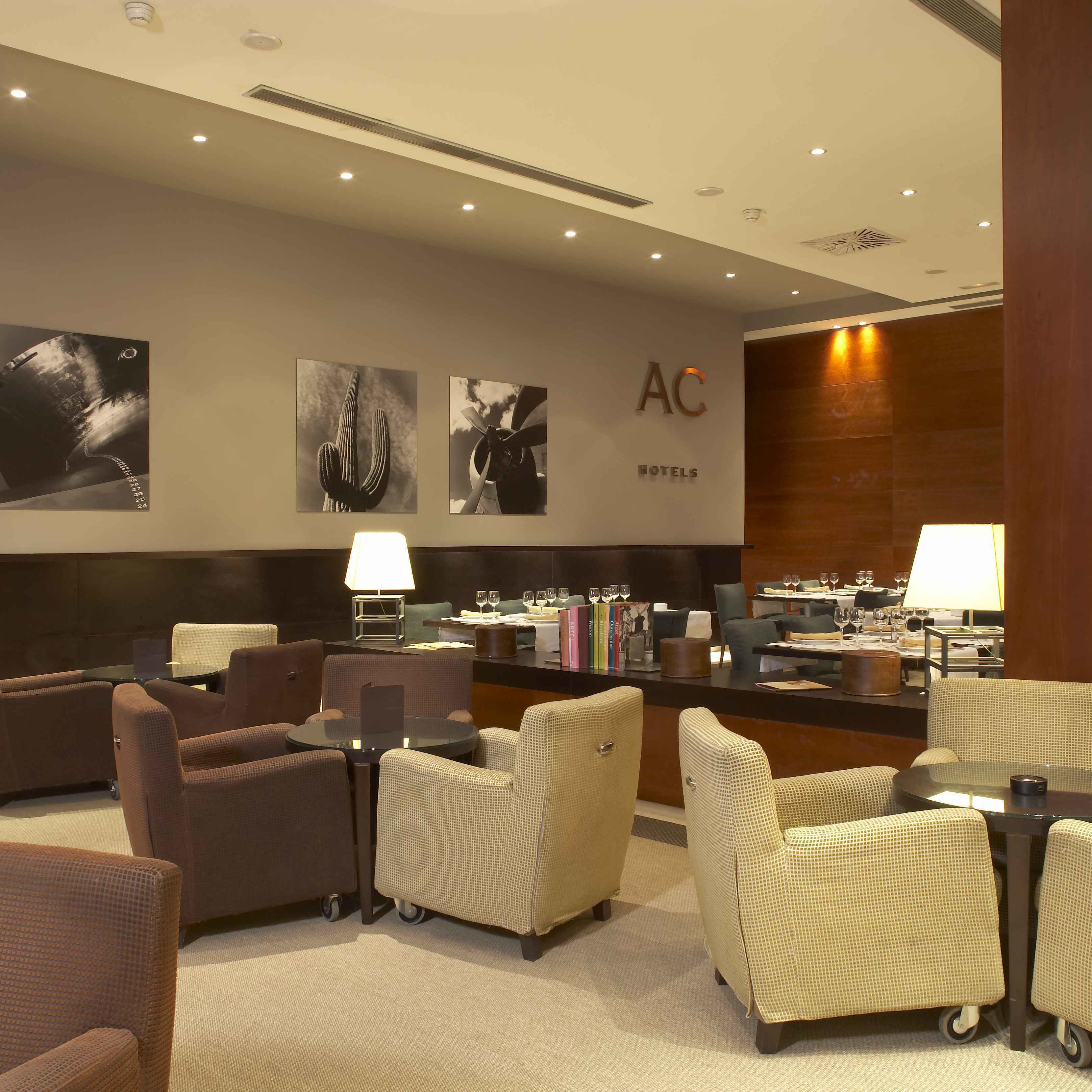 A hotel lobby with seating areas, a reception desk, and wall-mounted artwork.