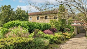 Un bâtiment en pierre avec un sentier de jardin menant à un portail en pierre.