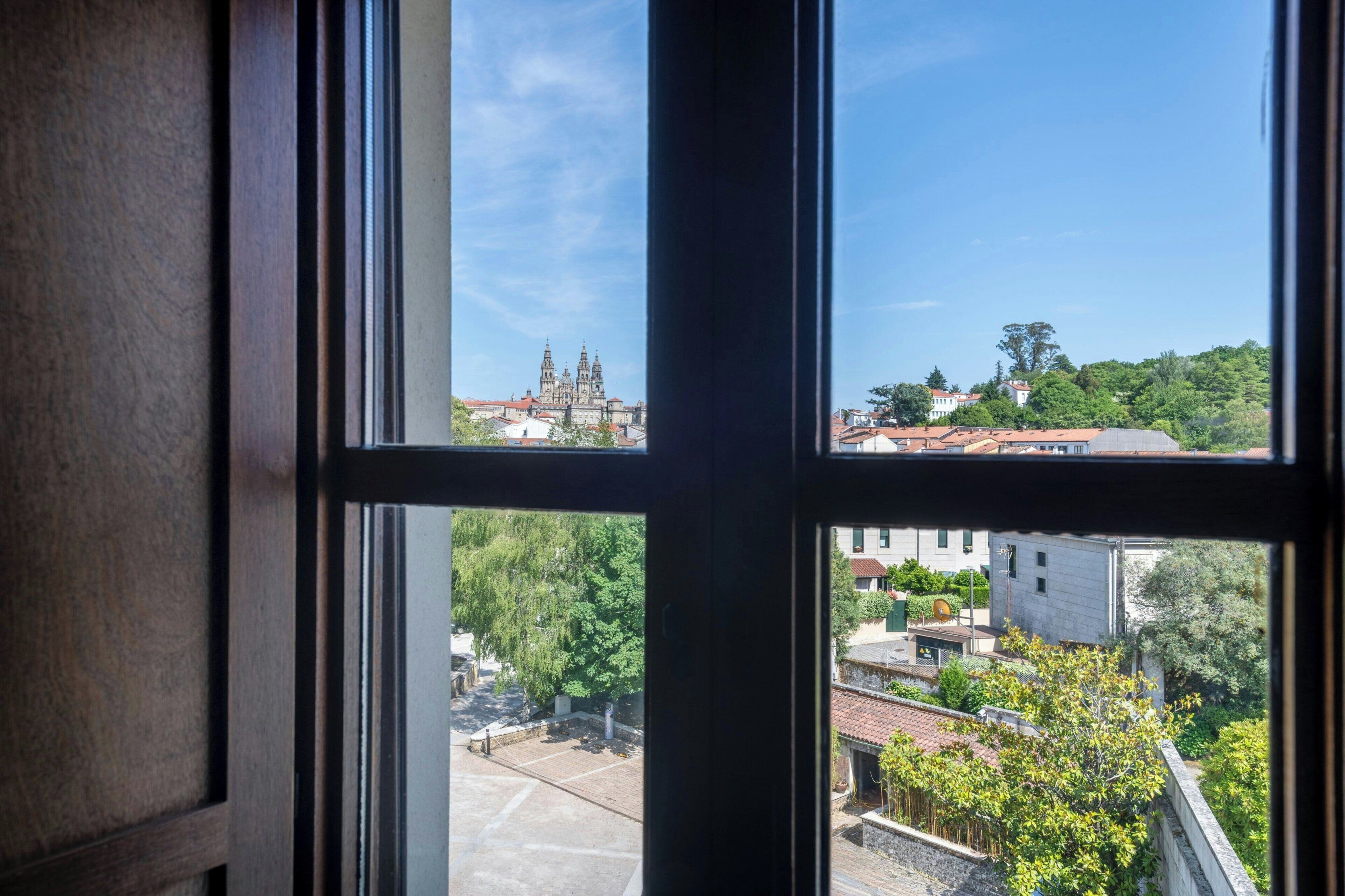 A window view of a cityscape with a prominent cathedral and residential buildings.