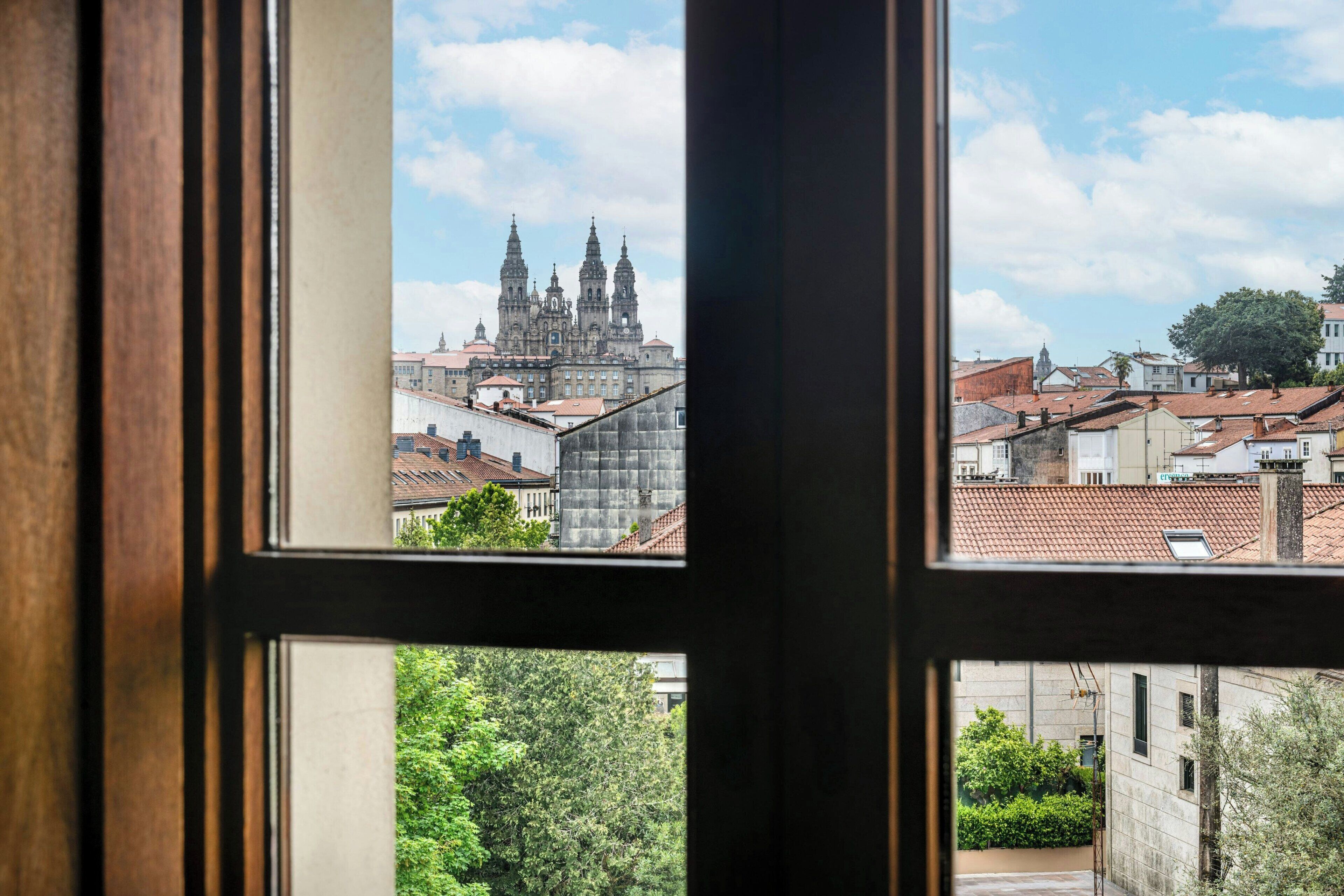 A window view of a cityscape with a prominent cathedral and surrounding buildings.