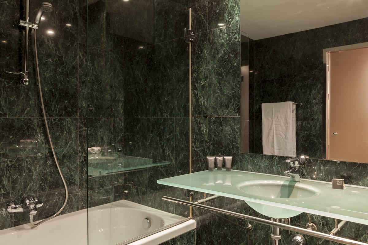 combined shower/bathtub, designer toiletries, hair dryer, towels