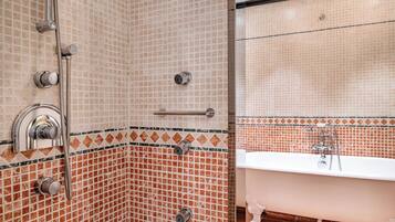 Un baño con ducha, bañera y paredes de azulejos.