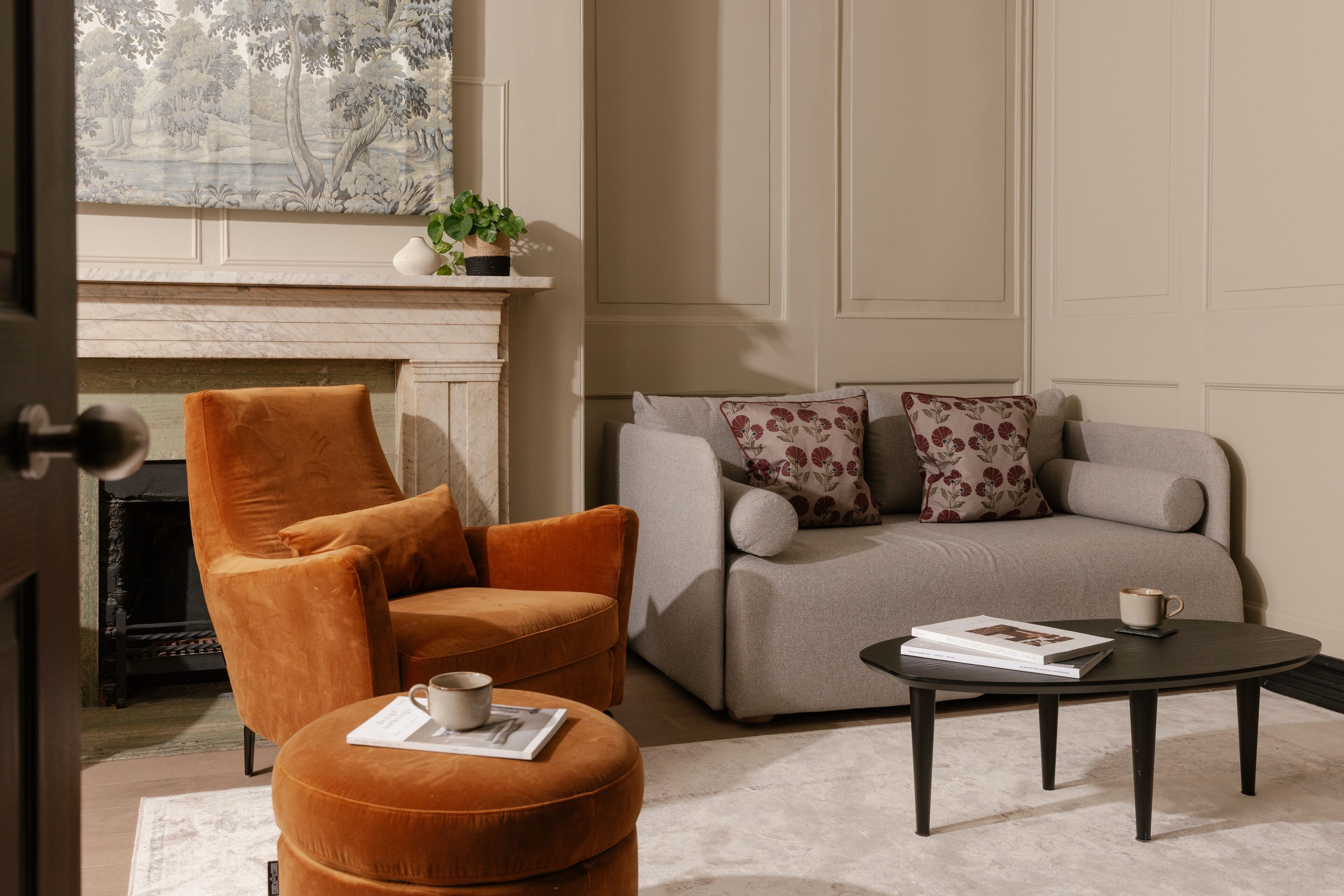 A living room with a fireplace, a sofa, an armchair, and a coffee table.
