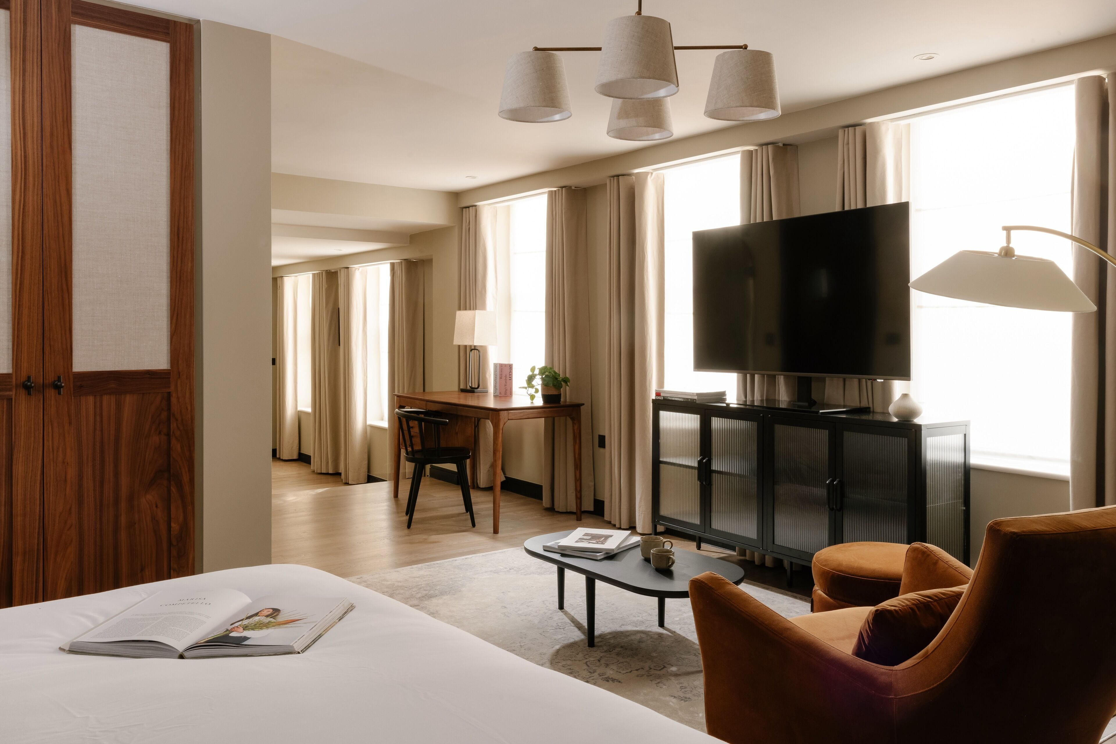 Een hotelkamer met een bed, een bureau, een televisie en een zithoek.