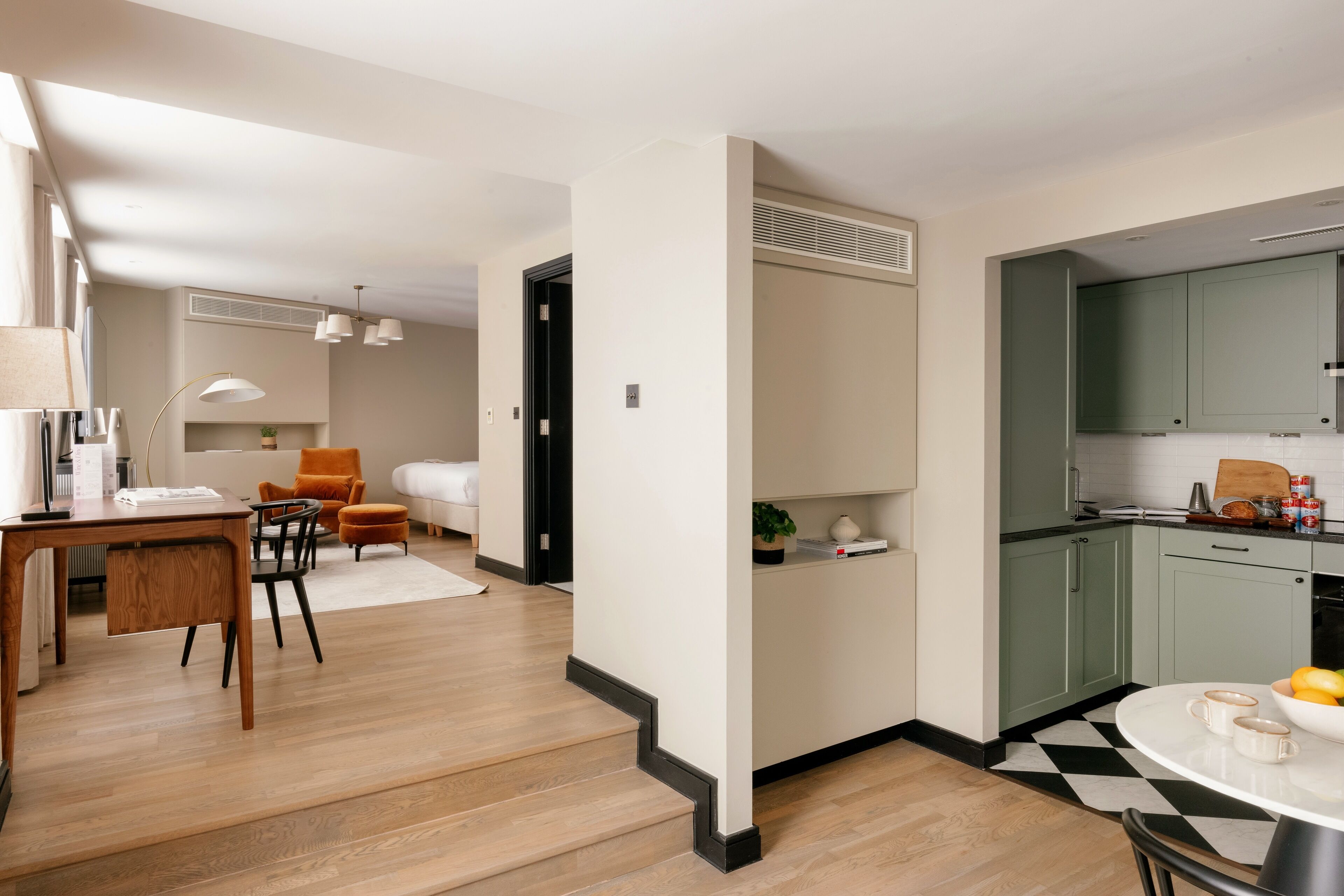 A modern apartment with a dining area, kitchen, and living space.