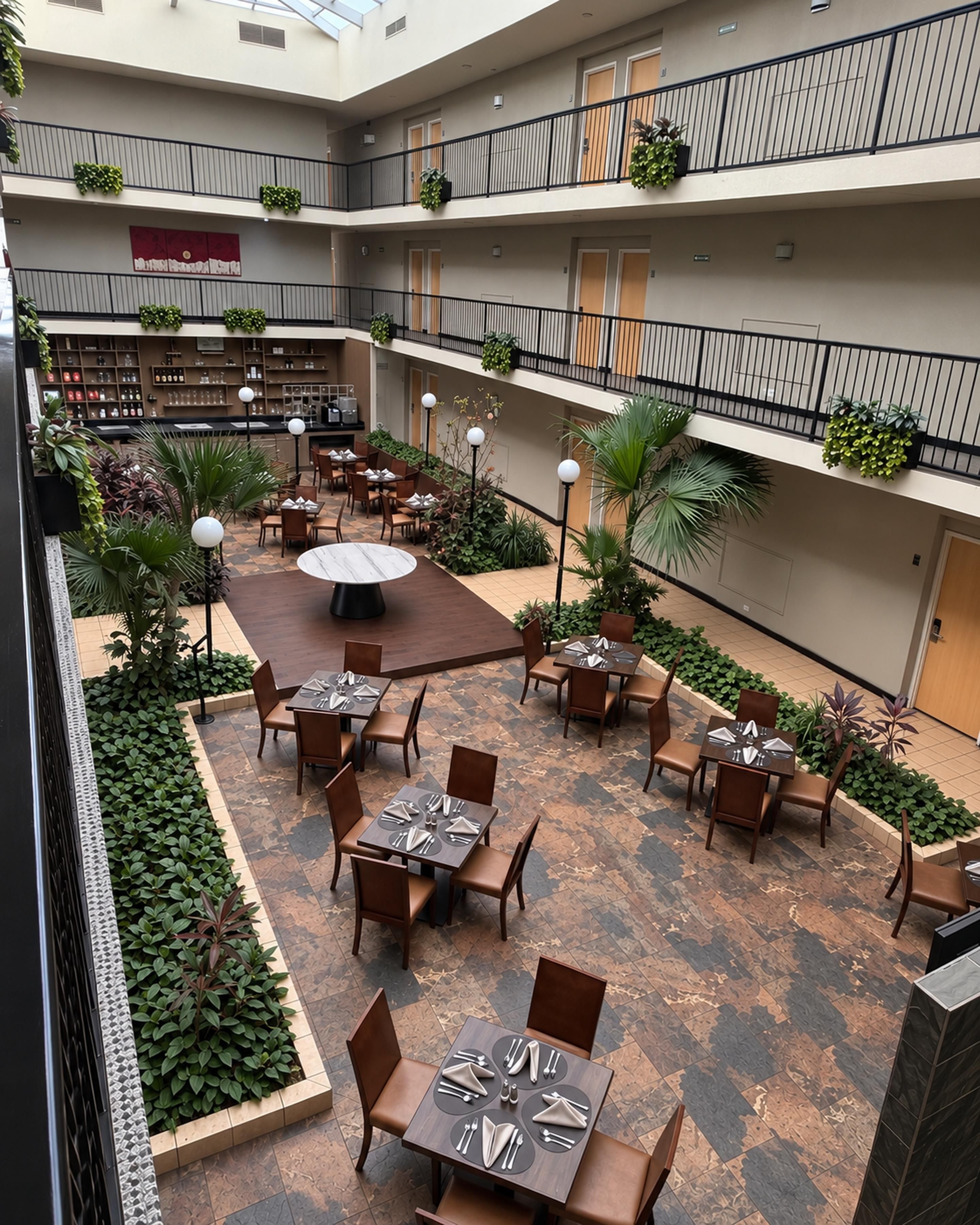 A multi-level outdoor dining area with tables and chairs, surrounded by potted plants and a central round table.