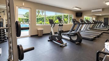 A gym with treadmills, a stationary bike, and weightlifting equipment.