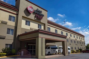 Un hotel Best Western Plus con entrada cubierta y varios espacios de estacionamiento.
