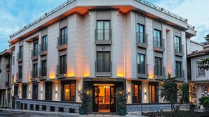 Un hotel de diverses plantes amb una entrada destacada, balcons i un cel serè.