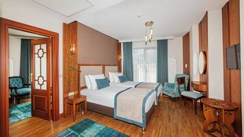A hotel room with a large bed, two bedside tables, a desk, a chair, and a TV.