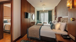 Habitació d'hotel amb dos llits, televisió, escriptori amb telèfon i vista a l'exterior per la finestra.