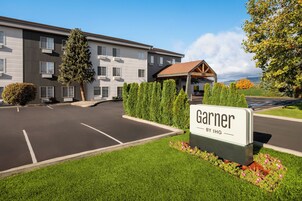 A Garner hotel with a parking lot, a covered outdoor area, and well-maintained landscaping.