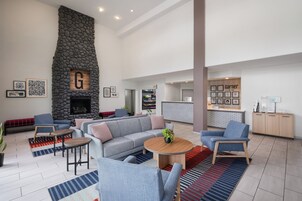 A spacious living area with a stone fireplace, a sofa set, a coffee table, and a reception desk.