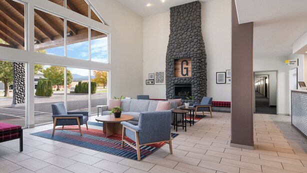 Un lobby amplio con chimenea de piedra, asientos cómodos y ventanas grandes que ofrecen vistas al exterior.