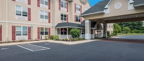 A Country Inn & Suites hotel with a covered entrance, multiple windows with shutters, and a parking lot.